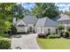 Charming home featuring manicured landscaping, a circular driveway, and an attached two-car garage at 5120 Falcon Chase Ln, Atlanta, GA 30342