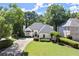 Charming painted brick home with manicured lawn, mature trees, and a basketball hoop on the driveway at 5120 Falcon Chase Ln, Atlanta, GA 30342
