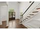 Stunning foyer features hardwood floors, a staircase with custom trim, and views through to the front yard at 5120 Falcon Chase Ln, Atlanta, GA 30342