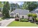 Beautifully landscaped traditional home with painted brick, dark roof, arched entry and circular driveway at 5120 Falcon Chase Ln, Atlanta, GA 30342
