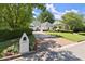 Beautiful painted brick home with an address marker, manicured lawn, and mature trees at 5120 Falcon Chase Ln, Atlanta, GA 30342