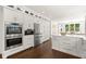 Gourmet kitchen featuring stainless steel appliances, white cabinets, island and hardwood floors at 5120 Falcon Chase Ln, Atlanta, GA 30342