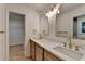 Bathroom with dual sinks, light wood cabinets, and a view into the closet at 315 N Fayette Dr, Fayetteville, GA 30214