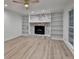 Bright living room featuring gray flooring, a whitewashed fireplace, and custom bookshelves at 315 N Fayette Dr, Fayetteville, GA 30214