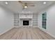 Living room featuring gray flooring, a fireplace, custom bookshelves, and a window at 315 N Fayette Dr, Fayetteville, GA 30214
