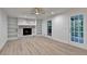 Bright living room featuring gray flooring, a fireplace, and custom bookshelves at 315 N Fayette Dr, Fayetteville, GA 30214