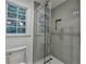 Modern tiled shower featuring glass door, a window, and a built-in niche at 315 N Fayette Dr, Fayetteville, GA 30214