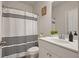 Well-lit bathroom with a white vanity, mirror, and shower with a stylish black and white curtain at 383 Crestbrook Ln, Dallas, GA 30157