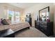 This bedroom offers a cozy retreat with neutral tones, a large dresser, and plenty of natural light for a peaceful sanctuary at 383 Crestbrook Ln, Dallas, GA 30157