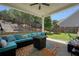 Inviting covered patio with comfortable seating, ceiling fan, and view of the backyard play area at 383 Crestbrook Ln, Dallas, GA 30157
