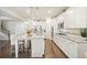 Well-equipped kitchen with stainless steel appliances, ample white cabinetry, granite countertops, and wood flooring at 383 Crestbrook Ln, Dallas, GA 30157