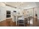 Modern white kitchen featuring stainless steel appliances, granite countertops, a central island, and wood floors at 383 Crestbrook Ln, Dallas, GA 30157
