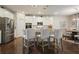 Open-concept kitchen featuring stainless steel appliances, white cabinets, granite countertops, and seating at the island at 383 Crestbrook Ln, Dallas, GA 30157