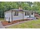 Renovated white brick home featuring a neatly landscaped yard, black trim, and a welcoming entrance at 450 Collier Ridge Nw Dr, Atlanta, GA 30318