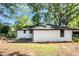 An eye-level view of the backyard shows the freshly painted home and lovely green trees at 1207 Ellington Dr, Morrow, GA 30260