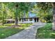 Beautiful front exterior featuring a well-maintained lawn, mature trees, and a charming, freshly painted facade at 1207 Ellington Dr, Morrow, GA 30260