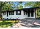 Beautifully updated one-story white brick home with black trim, a large carport, and fresh landscaping at 1207 Ellington Dr, Morrow, GA 30260
