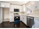 Bright kitchen featuring white cabinets, stainless steel appliances, and dark hardwood floors at 1207 Ellington Dr, Morrow, GA 30260