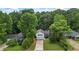 Aerial view of a charming home with a long driveway and mature landscaping, nestled among lush trees at 4255 Hidden Meadow Circle, Sugar Hill, GA 30518