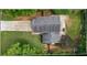 The aerial view displays the house, driveway and backyard with deck, nestled among mature trees at 4255 Hidden Meadow Circle, Sugar Hill, GA 30518
