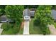 Aerial view showcases a well-maintained property with lush trees and a long driveway, nestled in a serene neighborhood at 4255 Hidden Meadow Circle, Sugar Hill, GA 30518