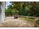 Spacious backyard wooden deck, perfect for outdoor entertaining, with lush greenery and a grill at 4255 Hidden Meadow Circle, Sugar Hill, GA 30518