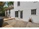 A house's backyard features a white exterior, a door, and a cozy concrete patio with an attached deck at 4255 Hidden Meadow Circle, Sugar Hill, GA 30518