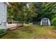 Expansive backyard with a wooden deck, mature tree, and a charming shed nestled among lush greenery at 4255 Hidden Meadow Circle, Sugar Hill, GA 30518