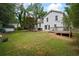 Large backyard showcasing a wooden deck, storage shed, mature trees, and lush greenery at 4255 Hidden Meadow Circle, Sugar Hill, GA 30518
