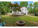 Spacious backyard featuring a cozy fire pit, a well-maintained lawn, and a charming wooden deck at 4255 Hidden Meadow Circle, Sugar Hill, GA 30518