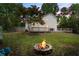 Spacious backyard featuring a cozy fire pit, a well-maintained lawn, and a charming wooden deck at 4255 Hidden Meadow Circle, Sugar Hill, GA 30518
