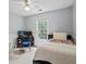 Bright bedroom with ceiling fan, carpet, and view of greenery outside the window at 4255 Hidden Meadow Circle, Sugar Hill, GA 30518