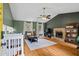 Inviting living room with stone fireplace, hardwood floors, a vaulted ceiling, and natural light at 4255 Hidden Meadow Circle, Sugar Hill, GA 30518