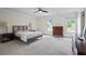 Spacious primary bedroom with natural light, ceiling fan and carpeting at 4255 Hidden Meadow Circle, Sugar Hill, GA 30518