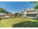 Large backyard featuring a lush lawn, mature trees, a screened porch, and a privacy fence at 4610 Admiral Ridge Way, Lilburn, GA 30047
