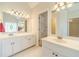 Bright bathroom featuring dual sink vanity and decorative mirror, with arched ceiling at 4610 Admiral Ridge Way, Lilburn, GA 30047