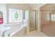 Bathroom features a soaking tub with decorative stained-glass window and glass enclosed shower at 4610 Admiral Ridge Way, Lilburn, GA 30047