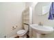 Charming half bath featuring a pedestal sink, toilet, and storage at 4610 Admiral Ridge Way, Lilburn, GA 30047