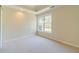 Neutral bedroom features plush carpeting, tray ceiling, and natural light from a large window at 4610 Admiral Ridge Way, Lilburn, GA 30047