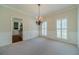 Traditional dining room featuring wainscoting, neutral paint, and a charming chandelier at 4610 Admiral Ridge Way, Lilburn, GA 30047