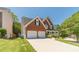 Charming brick home featuring a two-car garage and a well-manicured lawn, showcasing its attractive curb appeal at 4610 Admiral Ridge Way, Lilburn, GA 30047