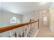 Upstairs hallway featuring hardwood railings, and natural light from the transom window at 4610 Admiral Ridge Way, Lilburn, GA 30047