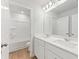 Modern bathroom with double sinks, white cabinets, a bathtub, and a large mirror at 7175 Brushwood Bend - Lot 36, Lithonia, GA 30058