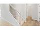 A staircase with neutral walls, black iron railings and light wood flooring leading upstairs at 7175 Brushwood Bend - Lot 36, Lithonia, GA 30058