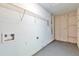 The utility room offers painted concrete floors, white walls, and a metal storage rack at 744 Martin Rd, Stone Mountain, GA 30088
