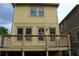 Yellow home exterior featuring a wooden deck, door, and multiple windows for natural light at 110 Hogue St, Atlanta, GA 30312