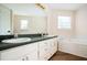 A primary bathroom with a double sink vanity, bathtub, and natural light at 409 Cold Springs Ln, Mcdonough, GA 30252