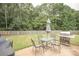 Outdoor patio with seating and grill perfect for entertaining surrounded by a spacious backyard at 704 Stonecrest Ln, Loganville, GA 30052