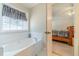 Bathroom featuring bathtub with jets and a bedroom in the background at 704 Stonecrest Ln, Loganville, GA 30052