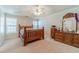 Bedroom with wood bed frame, ceiling fan, carpet floors, and a dresser at 704 Stonecrest Ln, Loganville, GA 30052